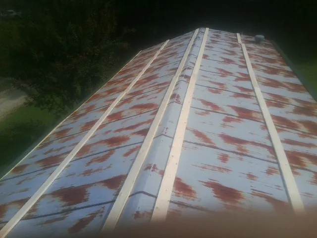 Rusted metal roof panels with new wood purlins before replacement — Storm Damage Roof Repair in Bath Springs by Roofing Brothers
