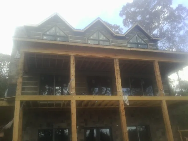 Dormers and porch framing on a large log home under construction — Roof Coating work by our crew in Bath Springs