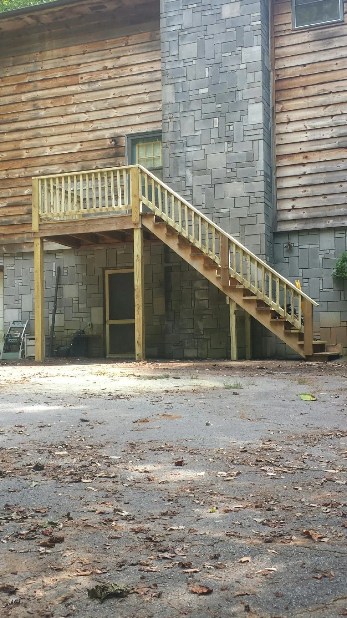 New pressure treated deck and stair landing on a log home in Bath Springs
