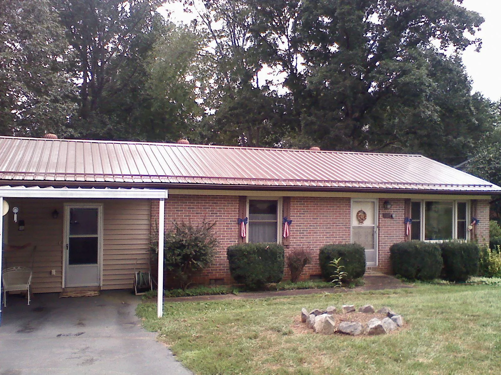 Bronze metal roof and carport on a brick ranch home — Roof Repair work by our crew in Bath Springs